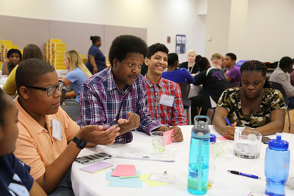 Commissioner Proctor engages with local youth during the Let's Balance! Budget Game, a game that provides firsthand look at the types of decisions the Leon County Commission has to make.